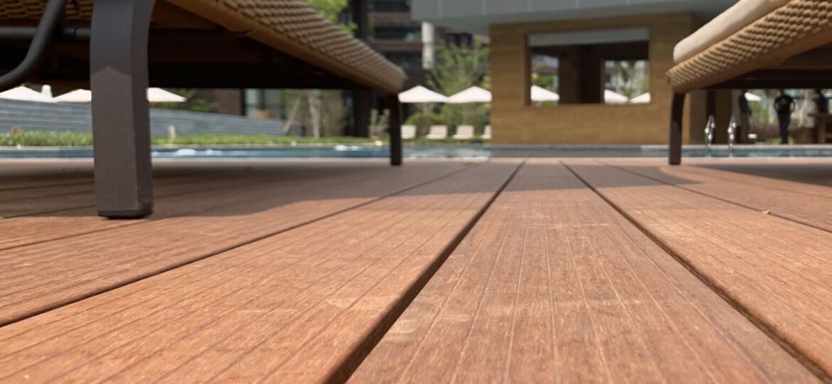 Chaises longues sur terrasse en bois, bâtiment moderne.
