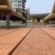 Chaises longues sur terrasse en bois, bâtiment moderne.