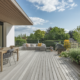 ESPACE DIMENSION Terrasse en bois avec mobilier extérieur et plantes verdoyantes.