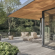 Terrasse en bois avec fauteuils et nature environnante.