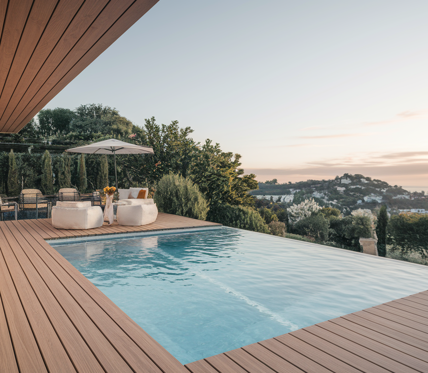 Terrasse en bois avec piscine au coucher du soleil.