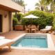 Terrasse avec piscine et mobilier en bois.