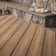 Terrasse en bois avec table basse en pierre.