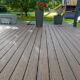 Terrasse en bois composite dans un jardin verdoyant.