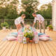 Couple préparant une table extérieure décorée.