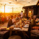 Dîner convivial sur terrasse au coucher du soleil.