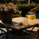 Jardin, table avec citronnade et fleurs colorées.