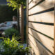 Jardin ensoleillé avec clôture en bois moderne.