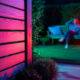 Clôture en bois illuminée, jardin nocturne.