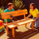 Deux personnes construisent un banc en bois sur terrasse.