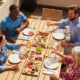 Personnes dînant autour d'une table en terrasse.