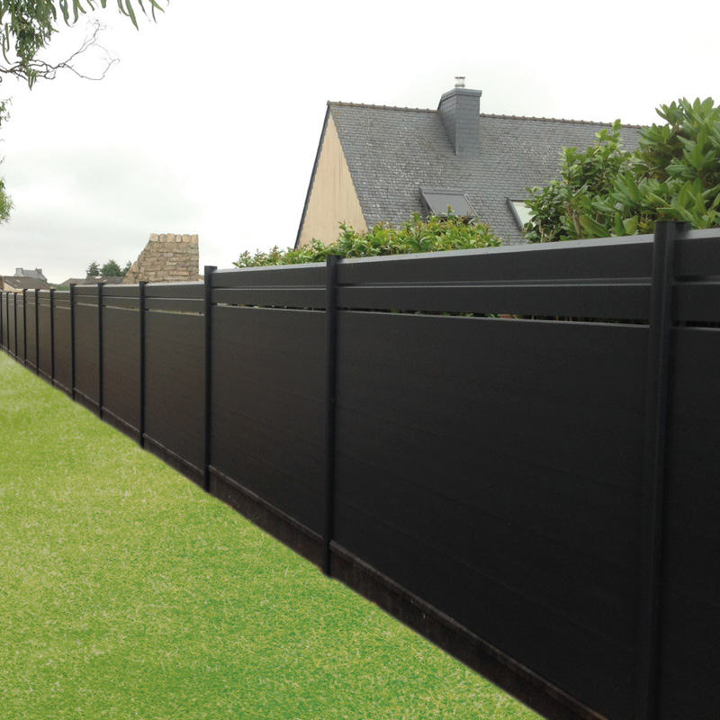 Clôture noire devant des maisons.