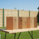 Échantillons de bois présentés sur table extérieure.