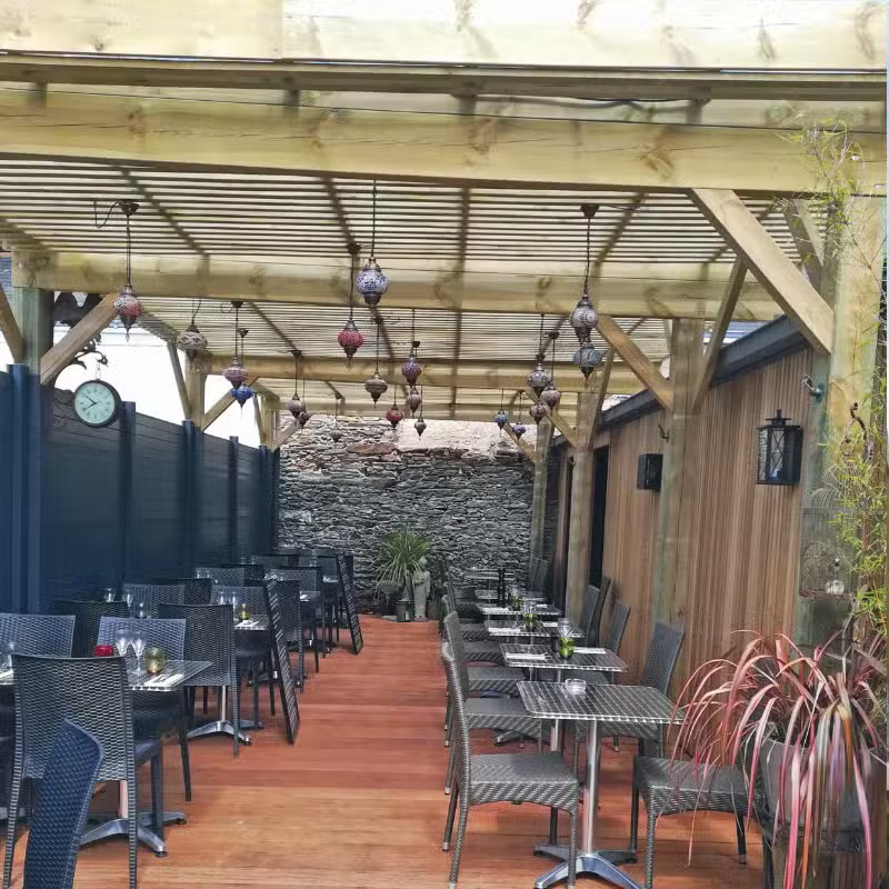 Terrasse couverte avec tables et chaises noires