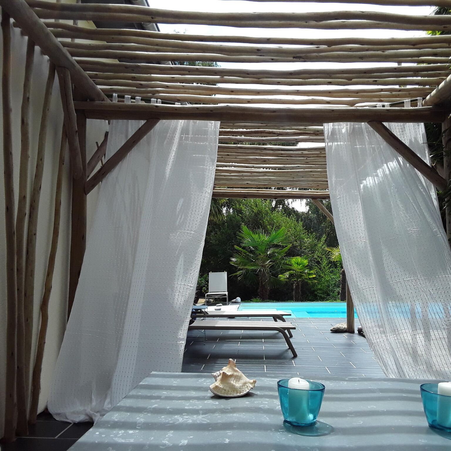 Patio avec piscine et transats, cadre relaxant.