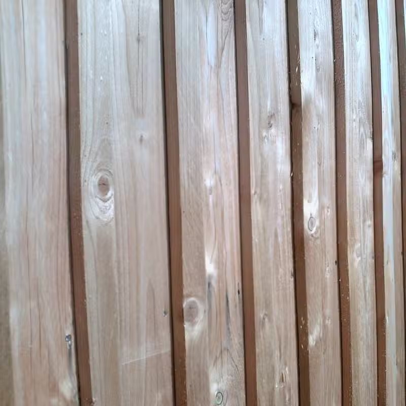 Clôture en bois avec motifs naturels.