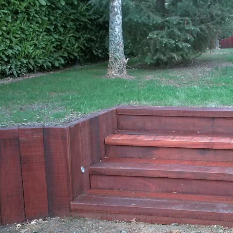 Escalier en bois extérieur dans un jardin verdoyant.