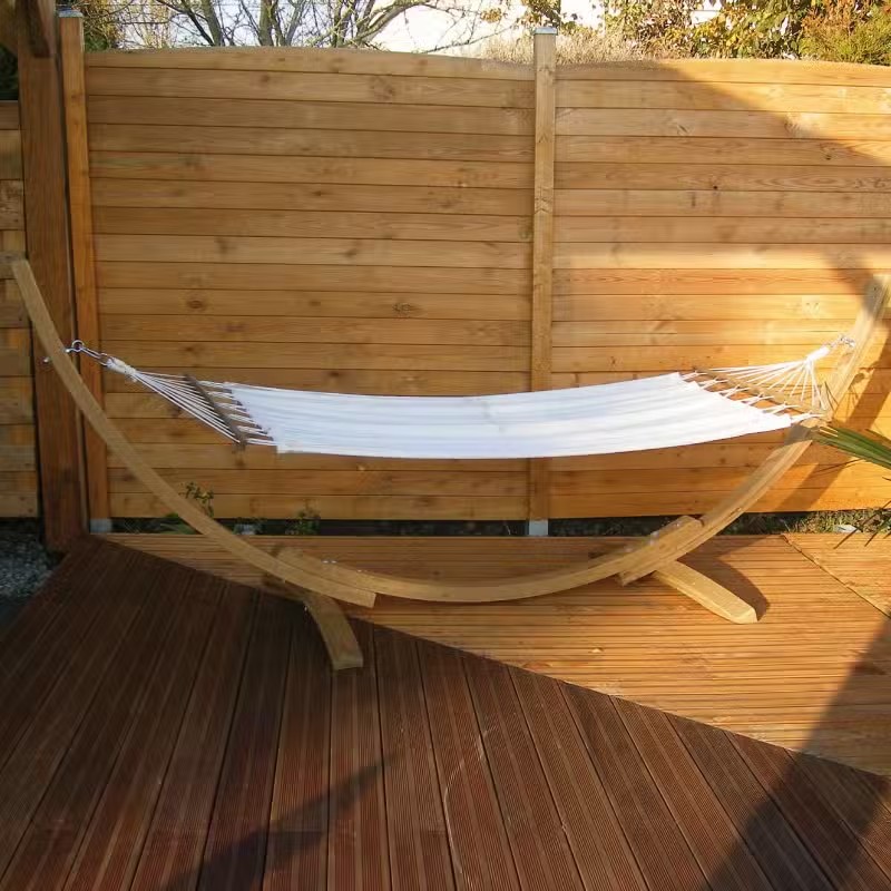 Hamac blanc sur support bois, terrasse bois.