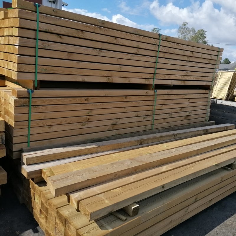 Planches de bois empilées dans un entrepôt.