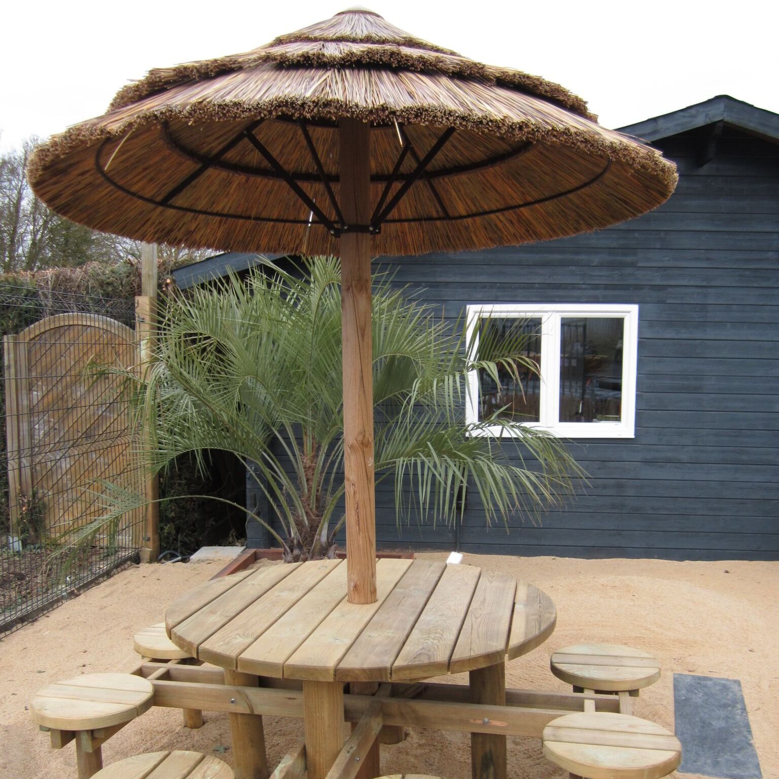 Table en bois avec parasol de chaume