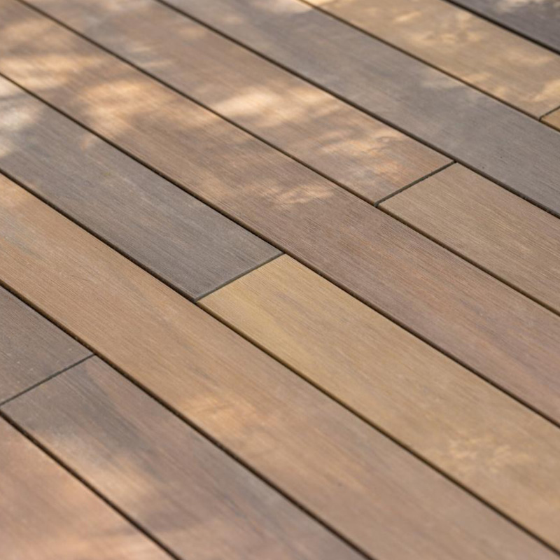 Plancher bois clair avec reflets de lumière.
