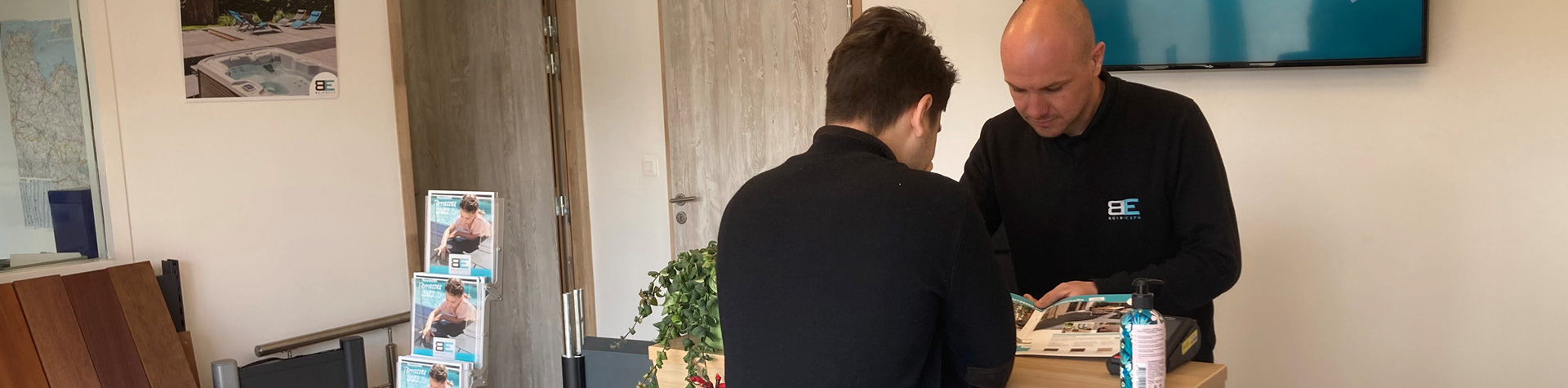 Discussion entre deux hommes à un comptoir.