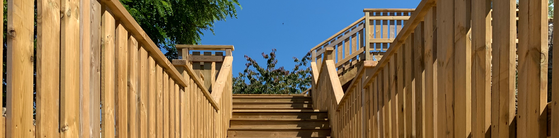 Escalier en bois sous ciel bleu.