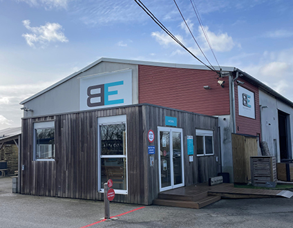 Bâtiment industriel avec logo sur façade.