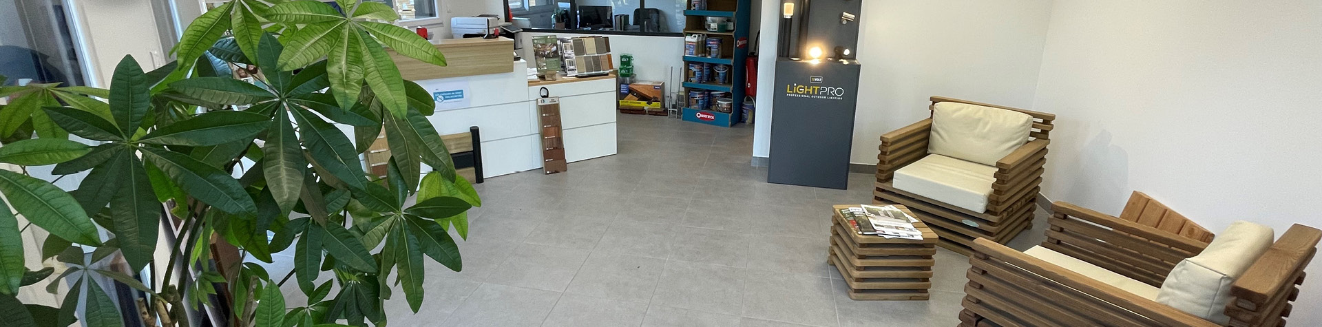 Salle d'attente avec plantes et meubles en bois.