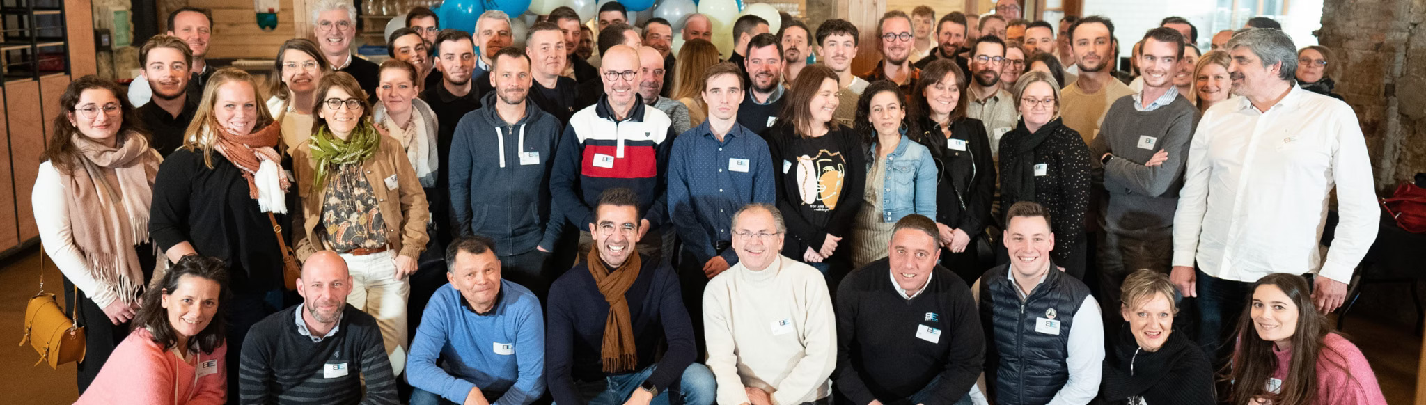 Groupe de personnes souriantes posant ensemble.