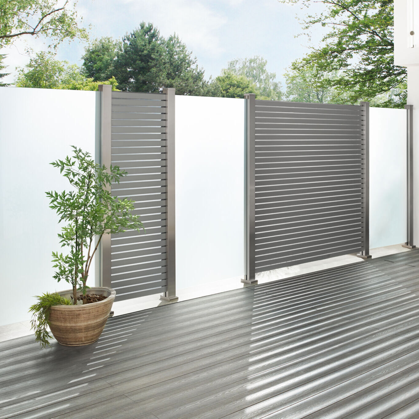 Clôture métallique moderne avec plante en pot.