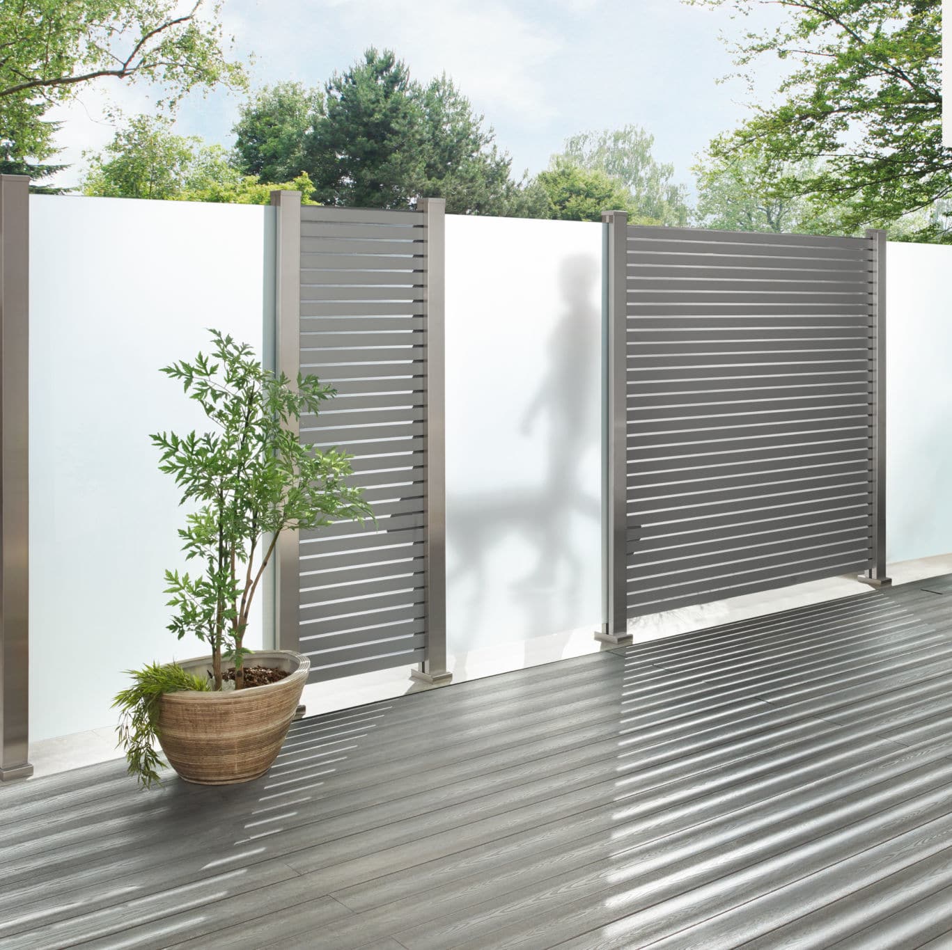 Clôture moderne avec plante en pot sur terrasse.