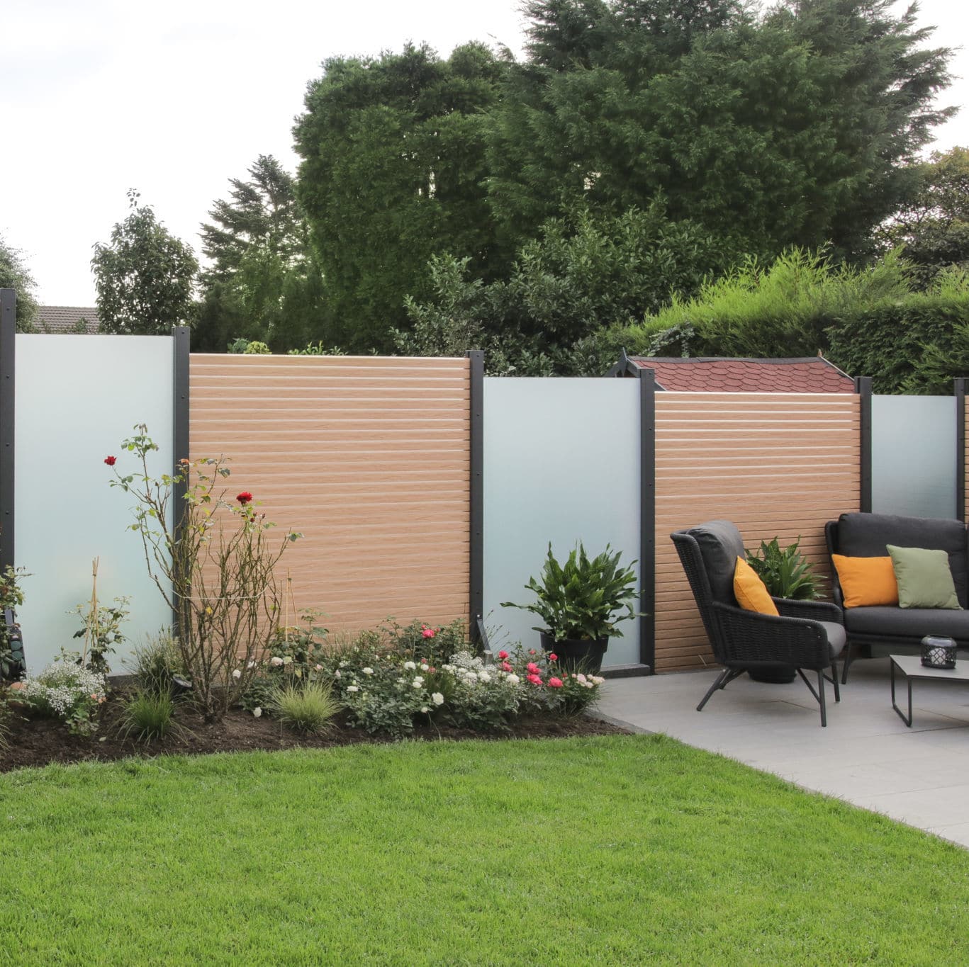 Jardin aménagé avec mobilier, pelouse et clôture moderne.