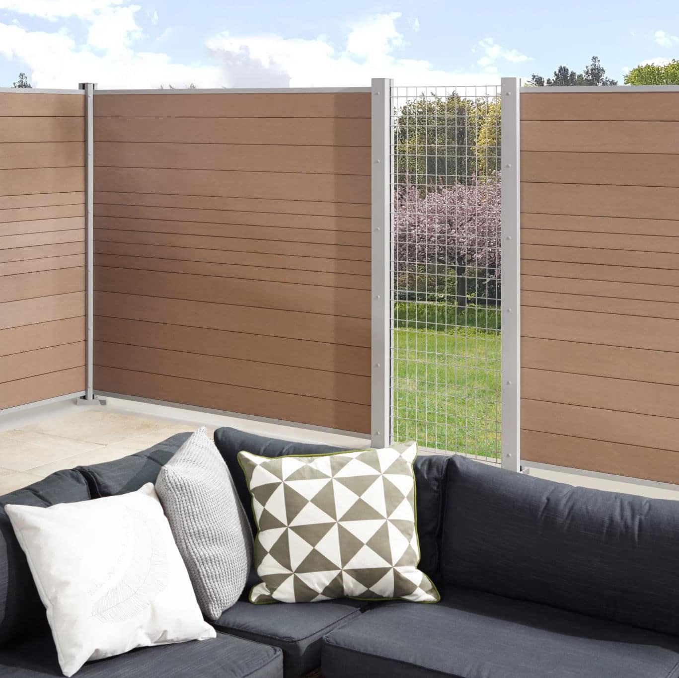 Clôture en bois et grillage, jardin et canapé.